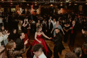 Guests dancing at a festive indoor celebration with elegant decor.